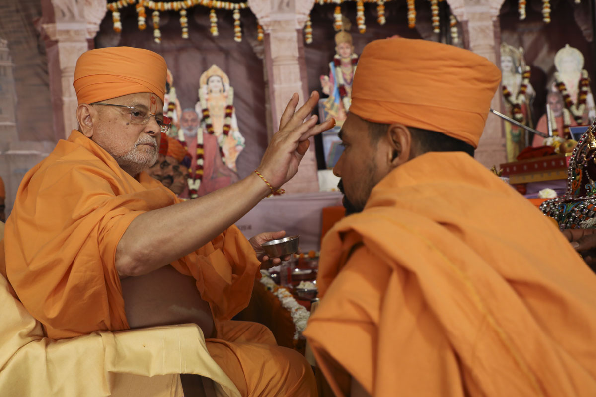 Pujya Ishwarcahran Swami applies chandlo to Yogiprem Swami