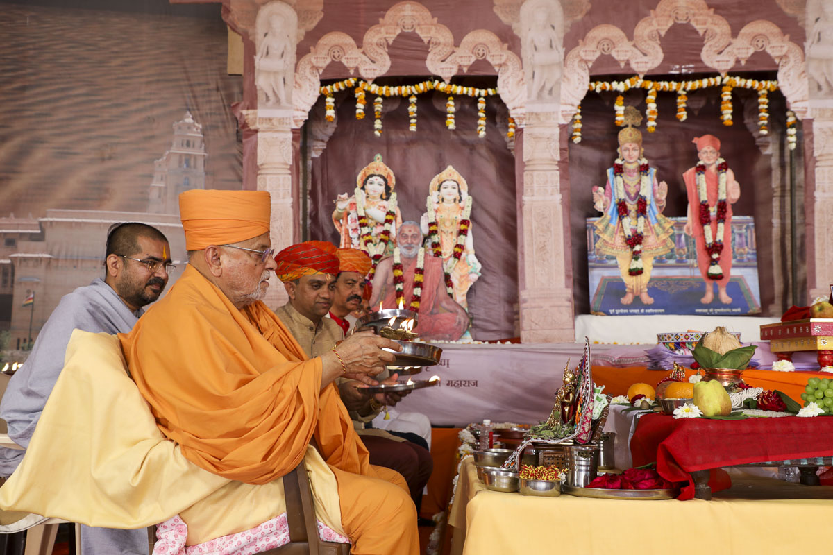 Pujya Ishwarcharan Swami and invited guests perform arti