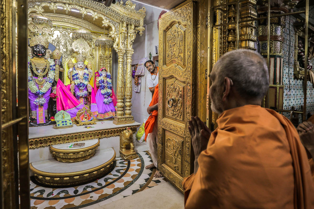 Swamishri engrossed in darshan of Shri Ranchhodji, Shri Narayanji and Shri Lakshmiji