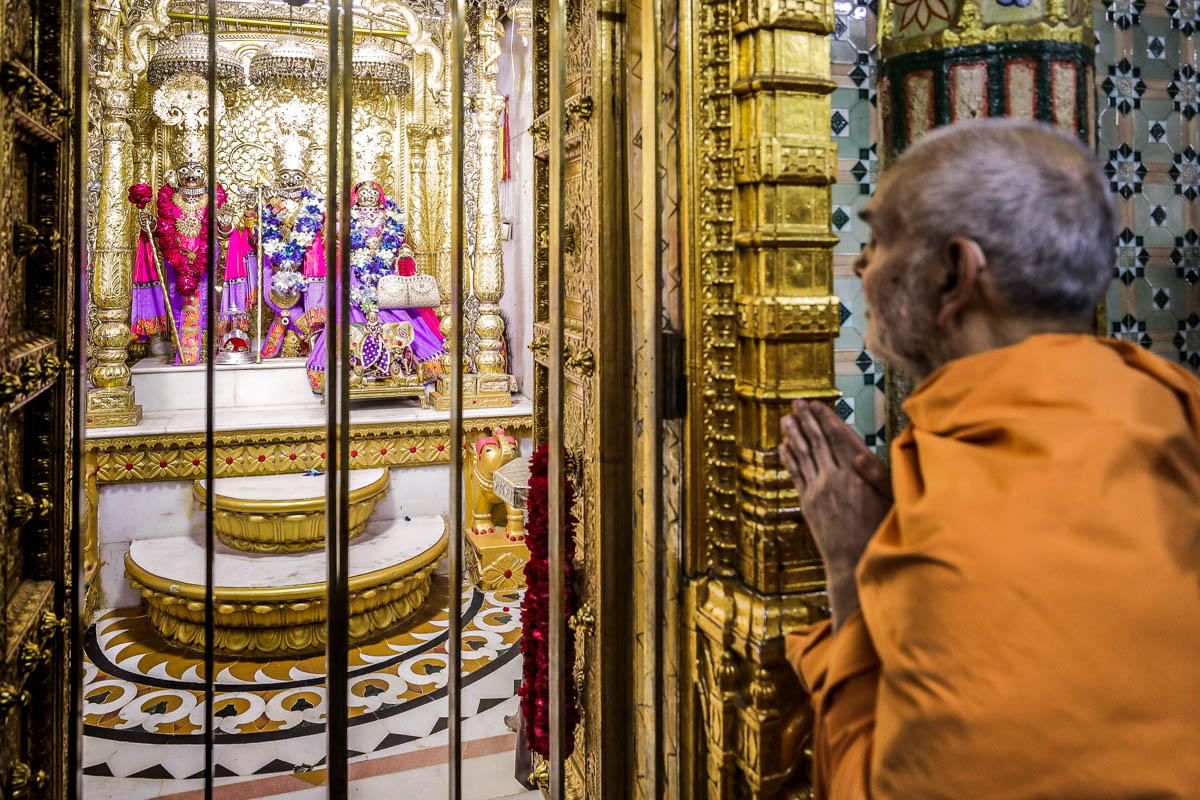 Swamishri engrossed in darshan of Shri Harikrishna Maharaj, Shri Krushnaji and Shri Radhikaji