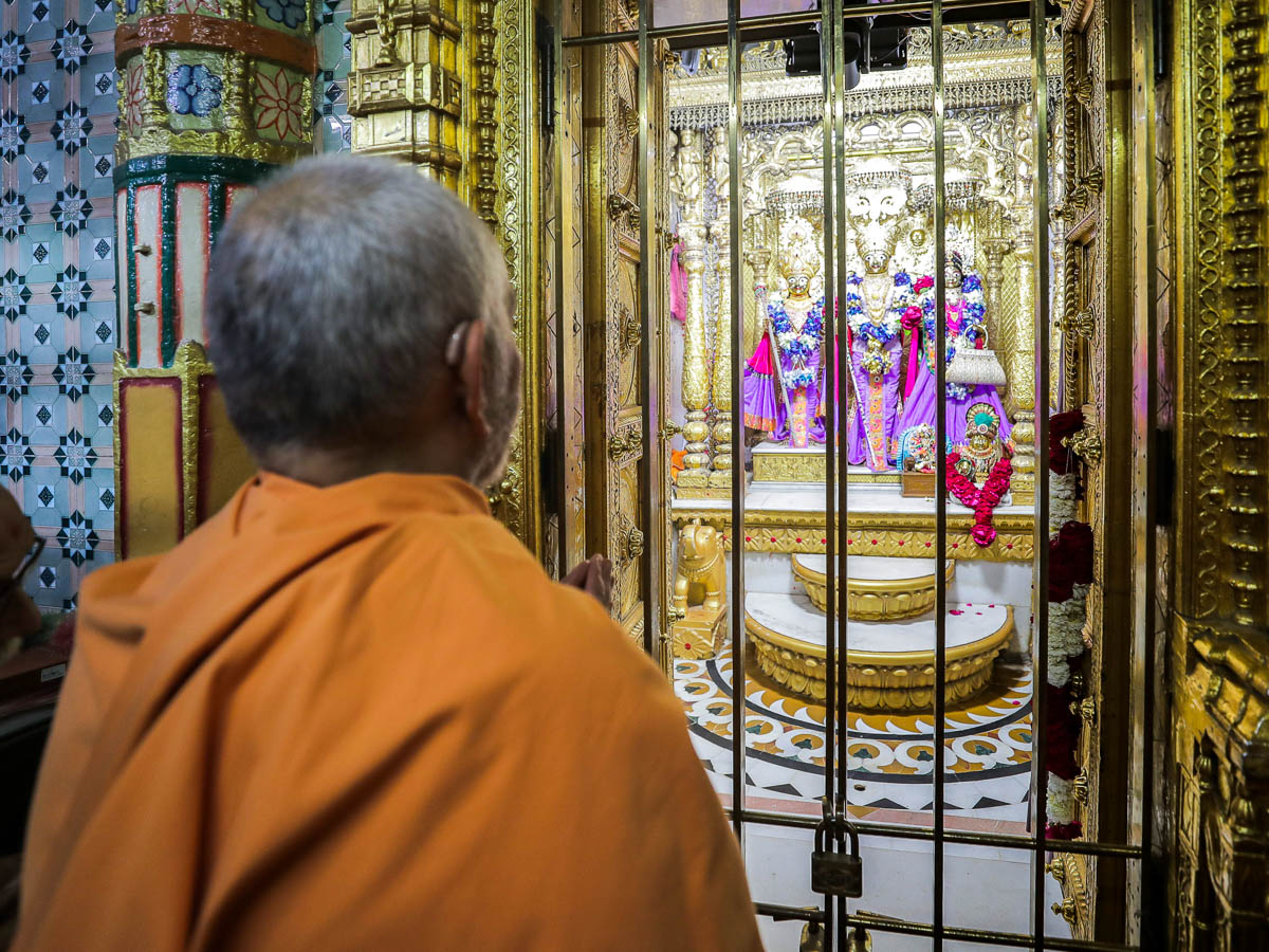 Swamishri engrossed in darshan of Shri Vasudevji, Shri Dharmadevji and Shri Bhaktimata