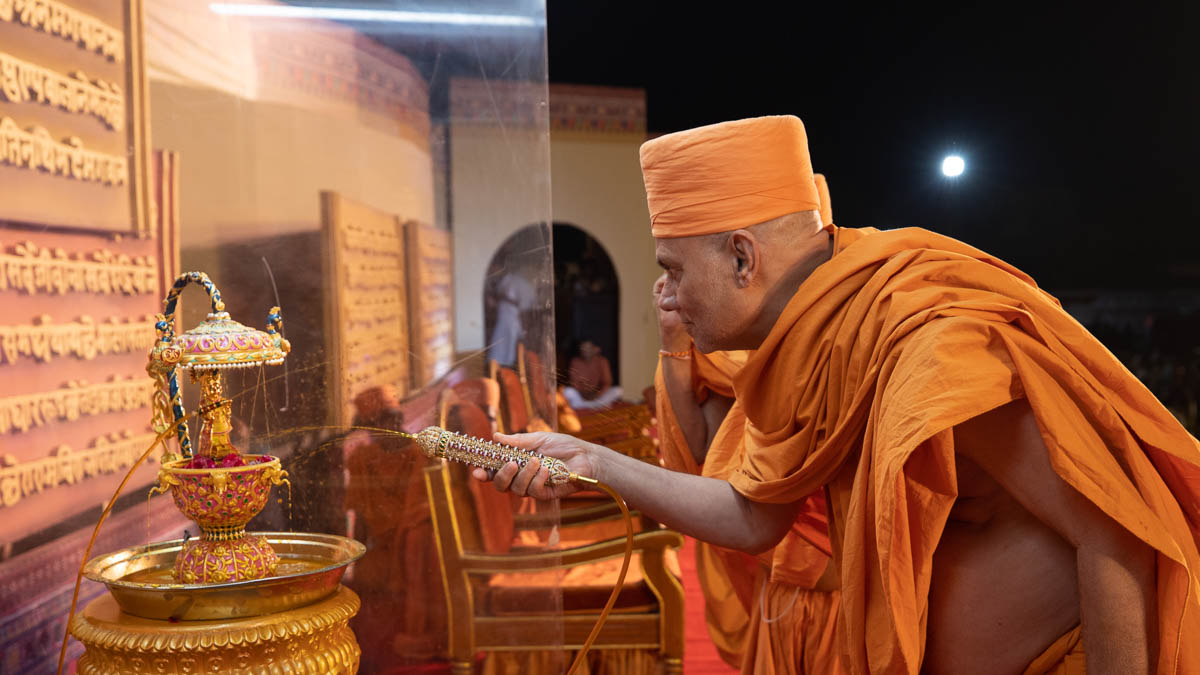 Pujya Viveksagar Swami sprays saffron-scented water on Shri Harikrishna Maharaj