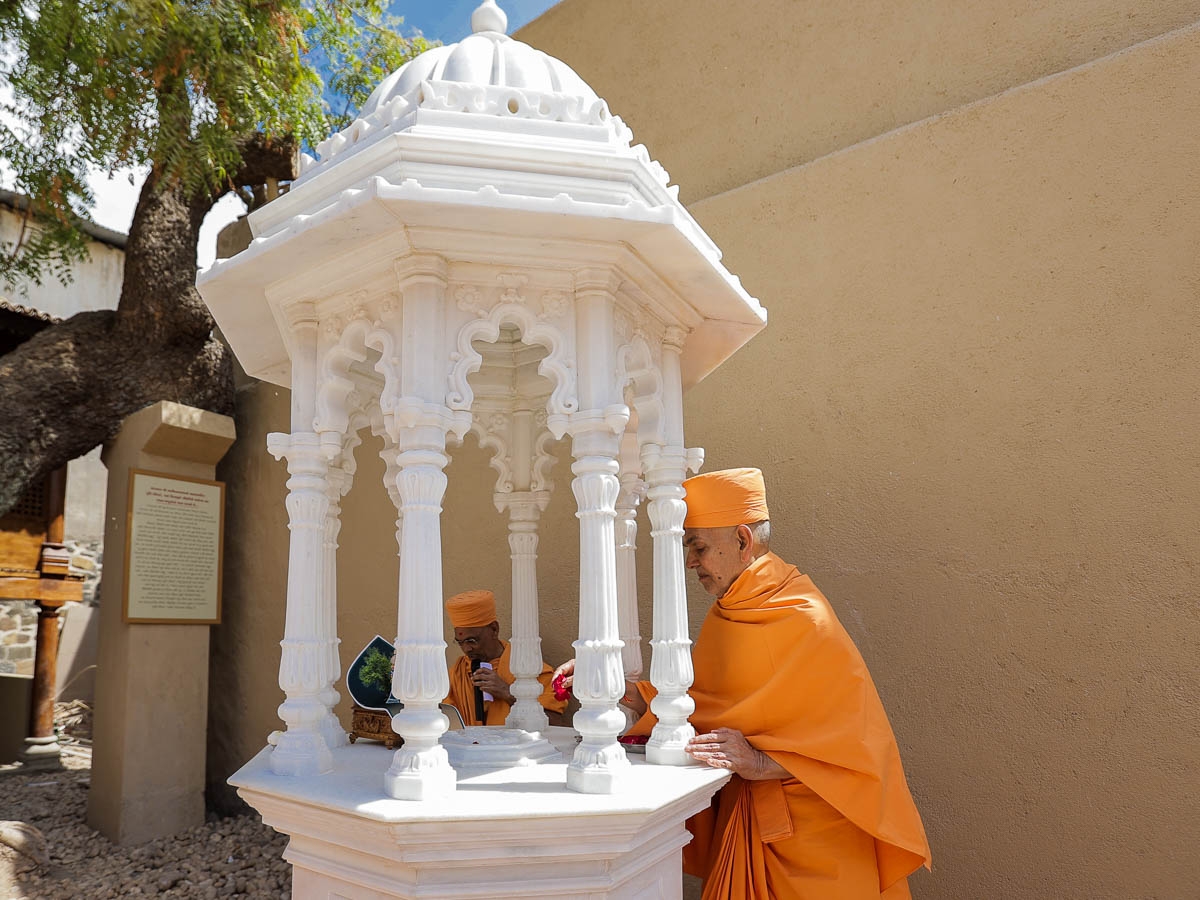 Swamishri performs pujan of the holy charanarvind of Bhagwan Swaminarayan in Shri Jiva Khachar's darbar