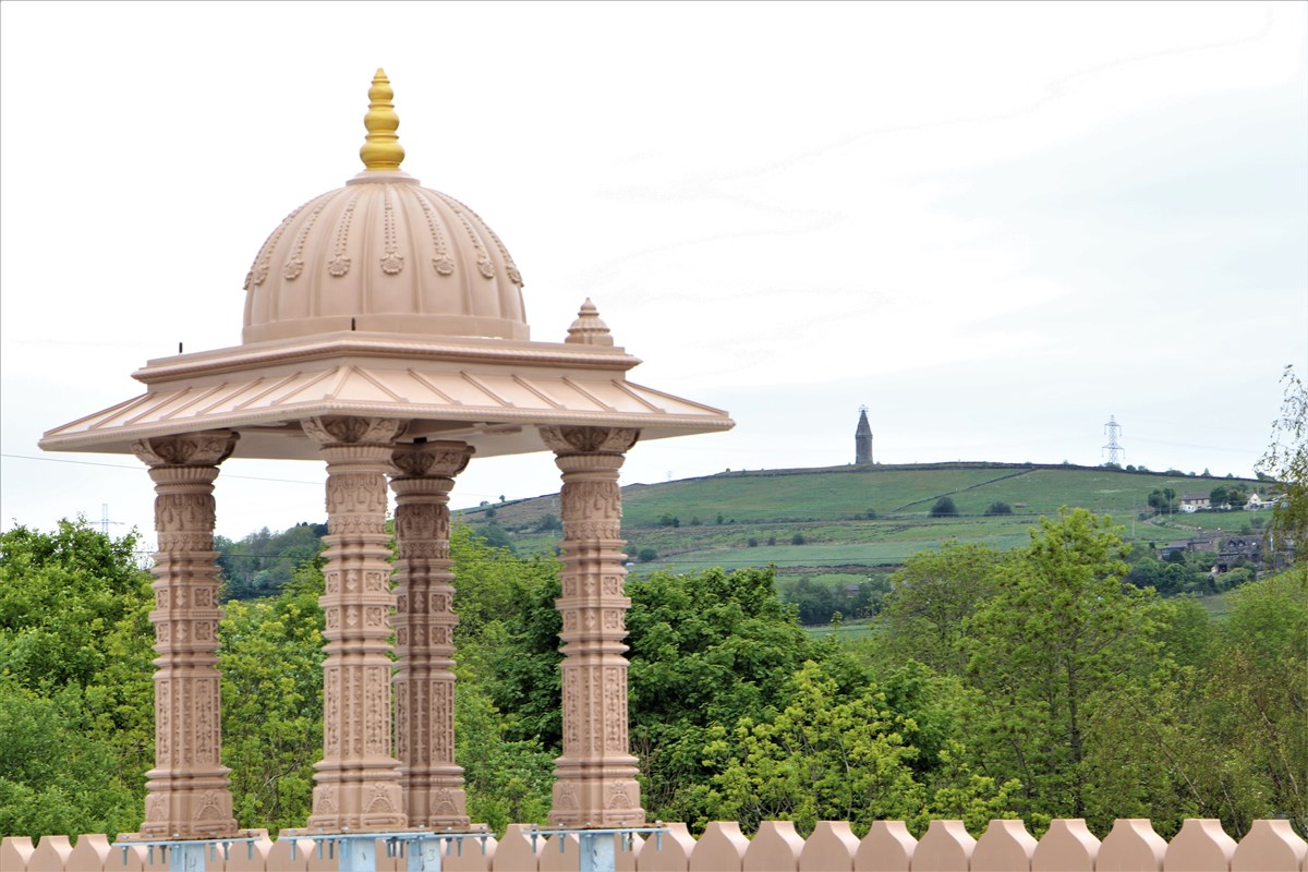 An almost finished chhatri atop the mandir, with Hartshead Pike, a Tameside landmark, visible in the distant background