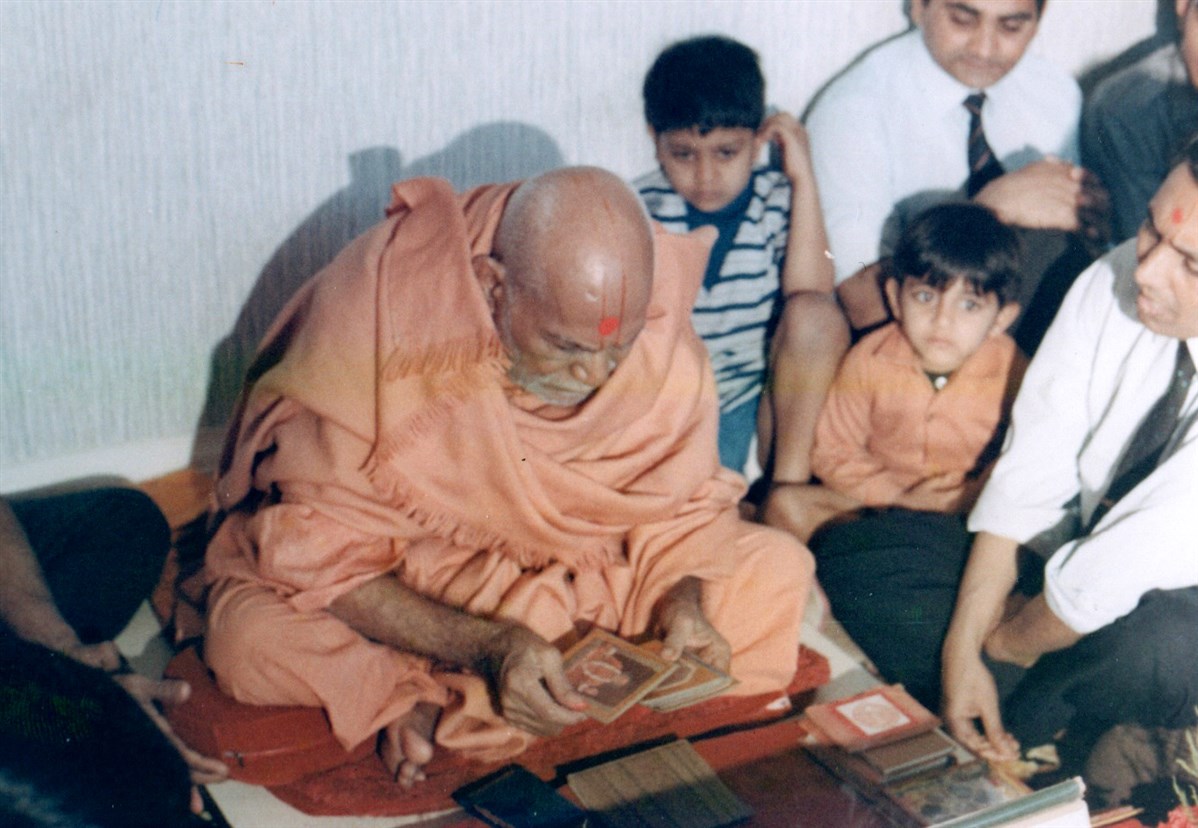 Yogiji Maharaj performs his morning puja surrounded by devotees