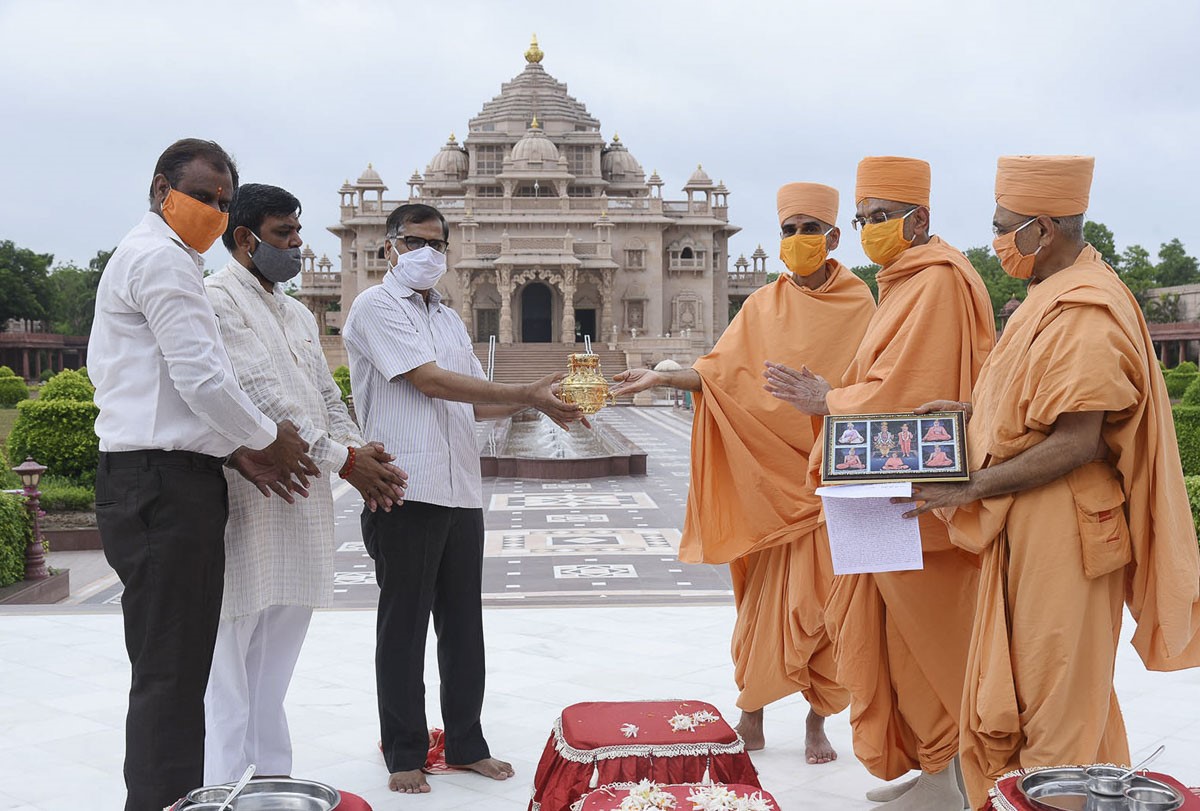 AnandSwarup Swami, VishwaVihari Swami (Kothari, Akshardham Gandhinagar) and ShrutiPrakash Swami present the kalash to the organizers of Shri Ram Mandir in Ayodhya