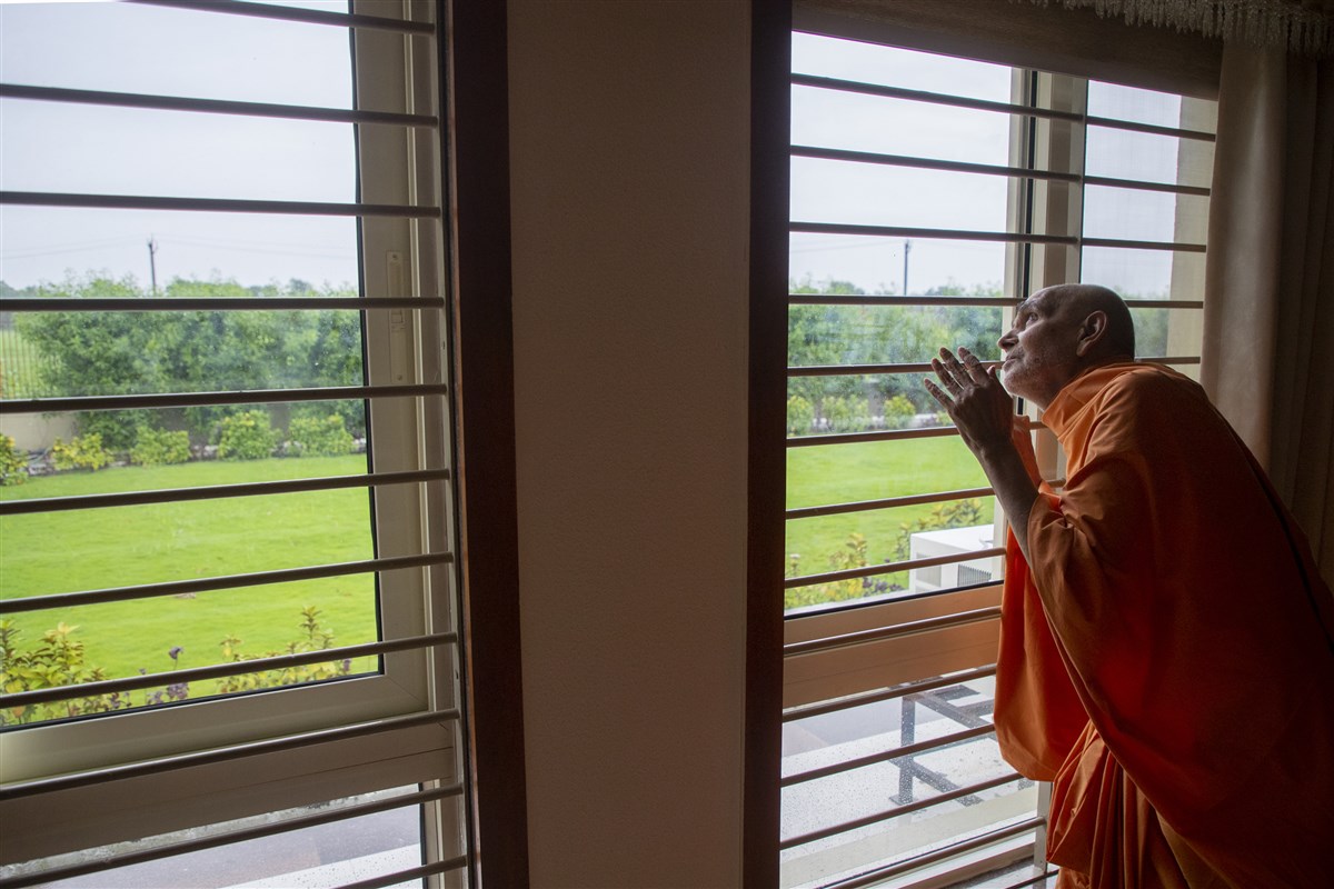 Swamishri observes the rain clouds