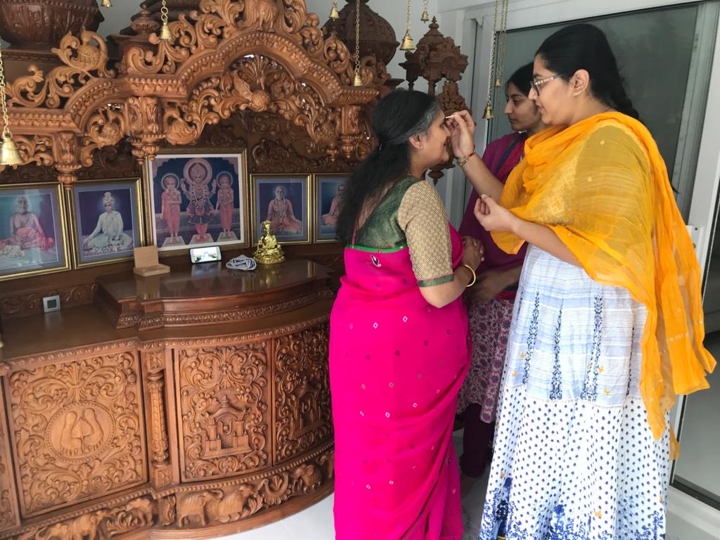 As per Hindu tradition, mahila devotees apply a kumkum chandlo on each other's foreheads to welcome one another to the virtual celebrations