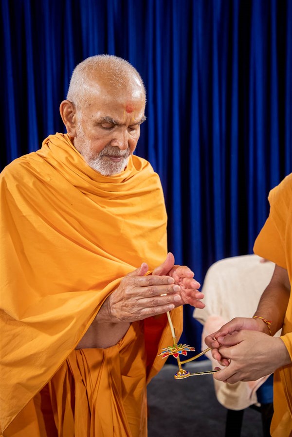 Swamishri takes aska after the arti