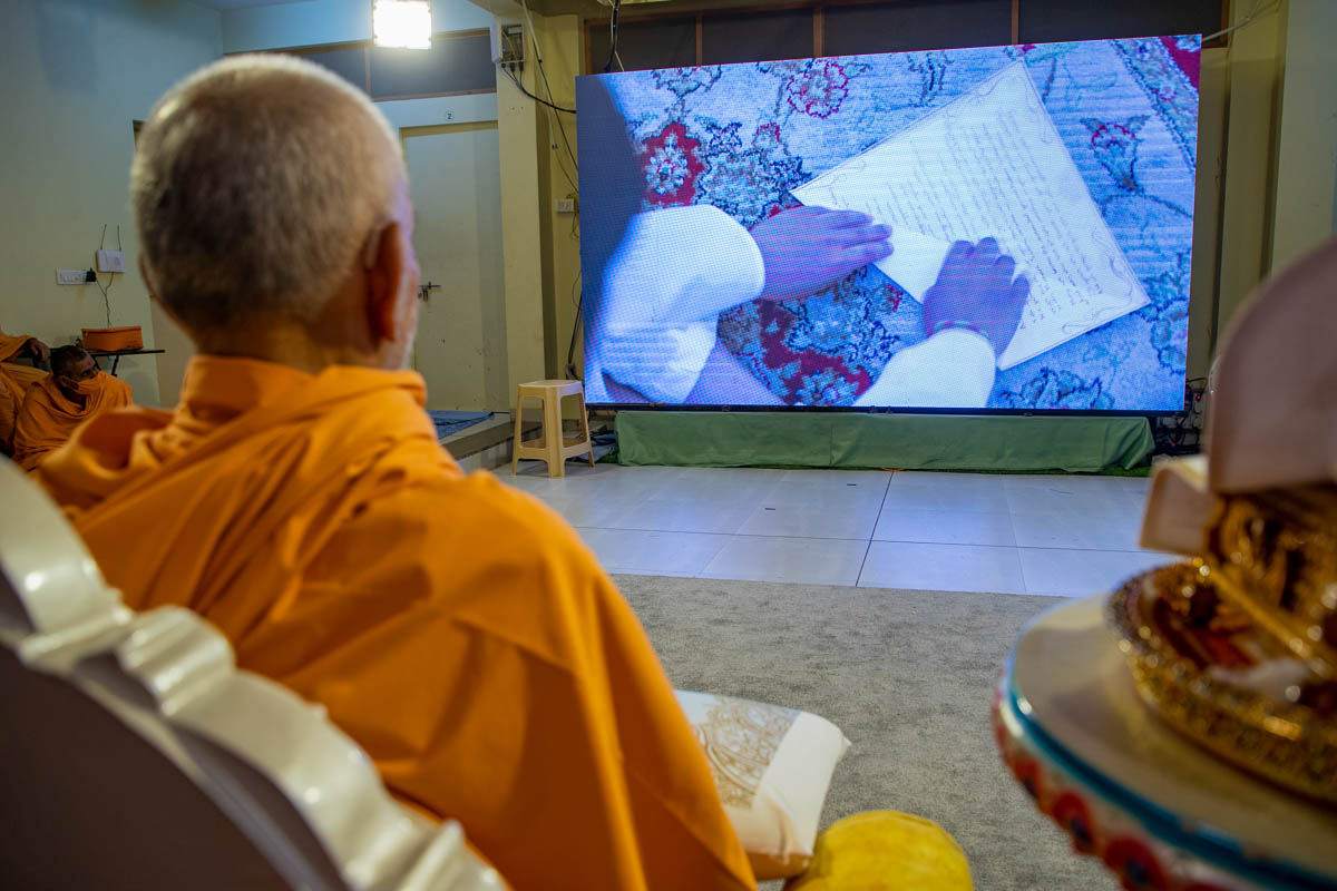 Swamishri watches the programme as the balak in London prepares his prayer for Mahant Swami Maharaj