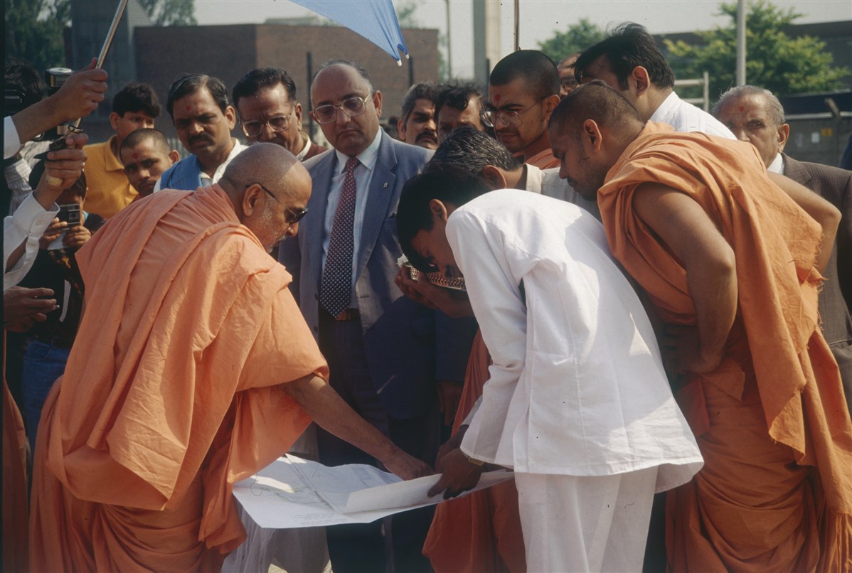 Pramukh Swami Maharaj on the new mandir site with the project team and trustees
