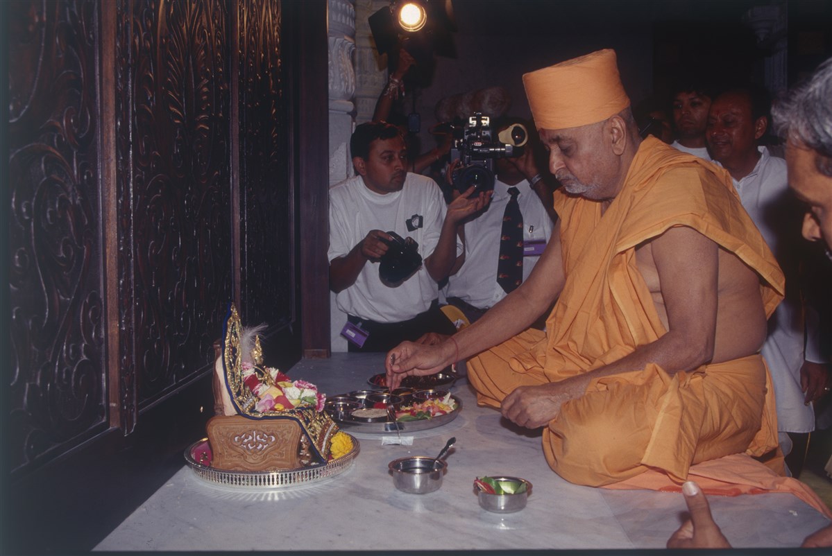 Pramukh Swami Maharaj, seated in the central shrine before Shri Harikrishna Maharaj, performs the vastu pujan (pre-image installation ceremony) on 18 August 1995