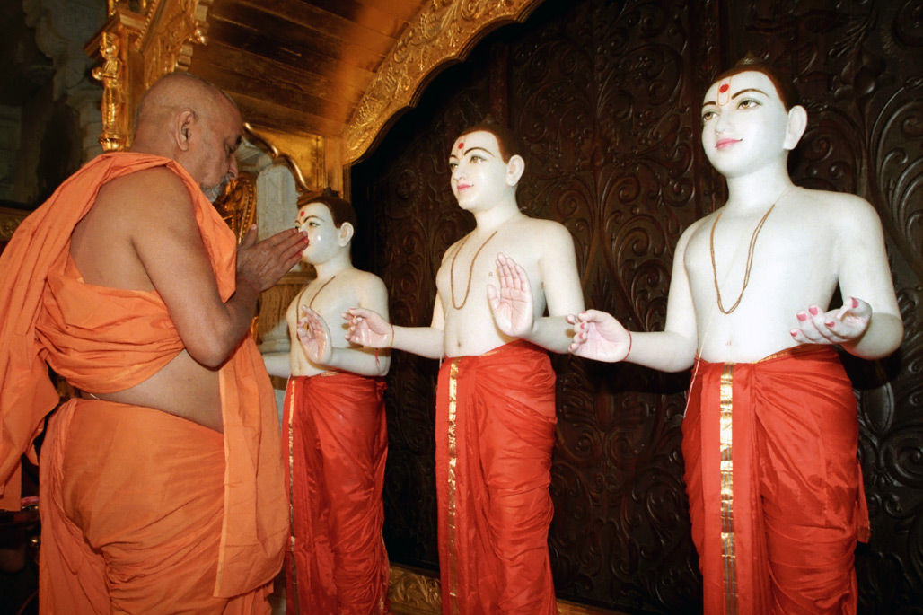 20 August 1995 – the day of the grand opening of the mandir. Pramukh Swami Maharaj stands before the murti of Bhagwan Swaminarayan as the image installation ceremony is under way
