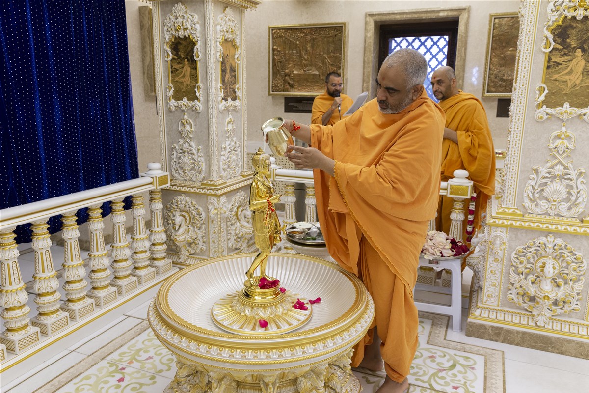 Yogvivekdas Swami bathes Shri Nilkanth Varni Maharaj with milk