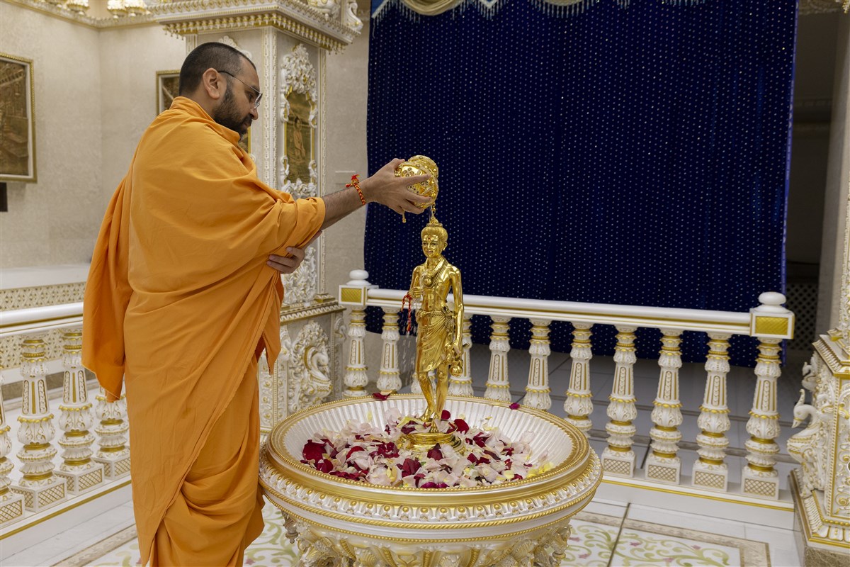 Yogikirtandas Swami bathes Shri Nilkanth Varni Maharaj with water