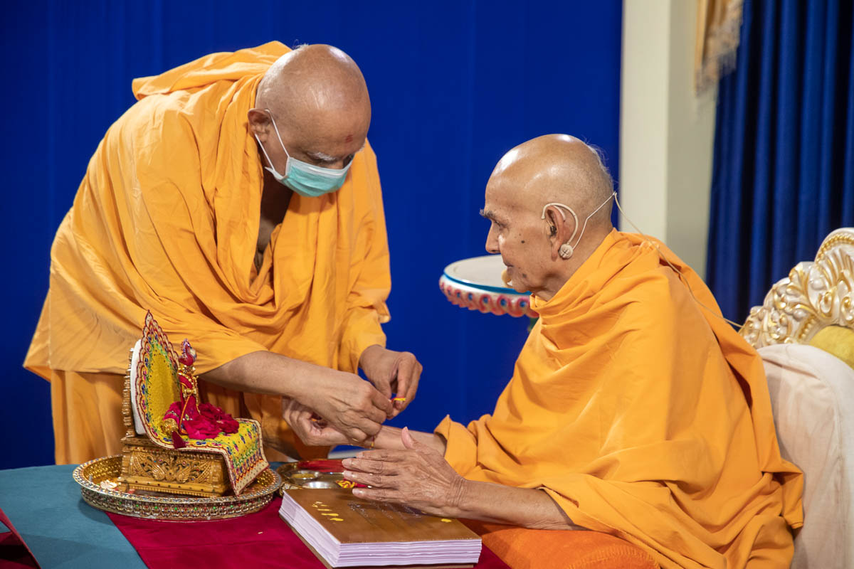 Atmaswarup Swami ties a nadachhadi to Swamishri