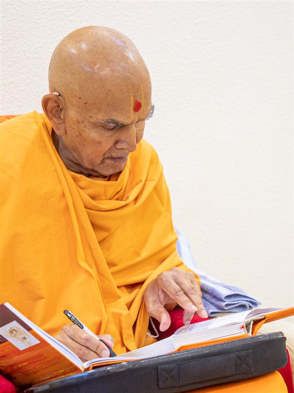Swamishri writes notes from 'Purushottam Bolya Prite'