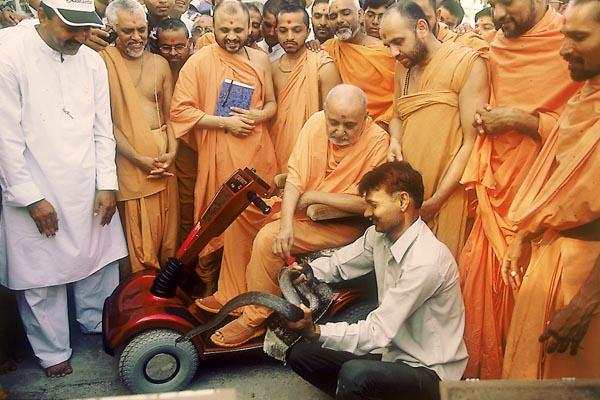  Swamishri blesses the devotee holding a snake