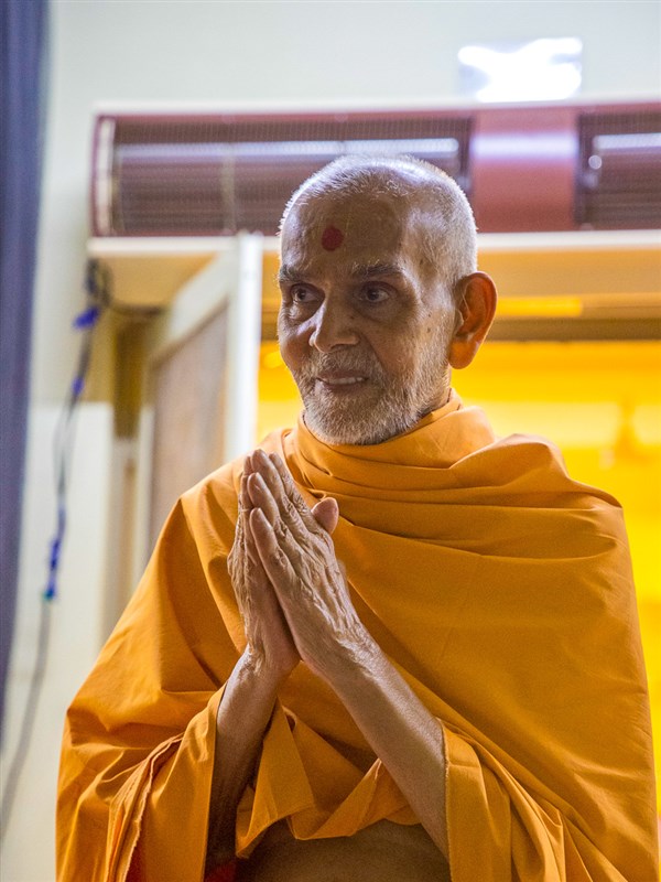 Swamishri greets all with folded hands in the evening