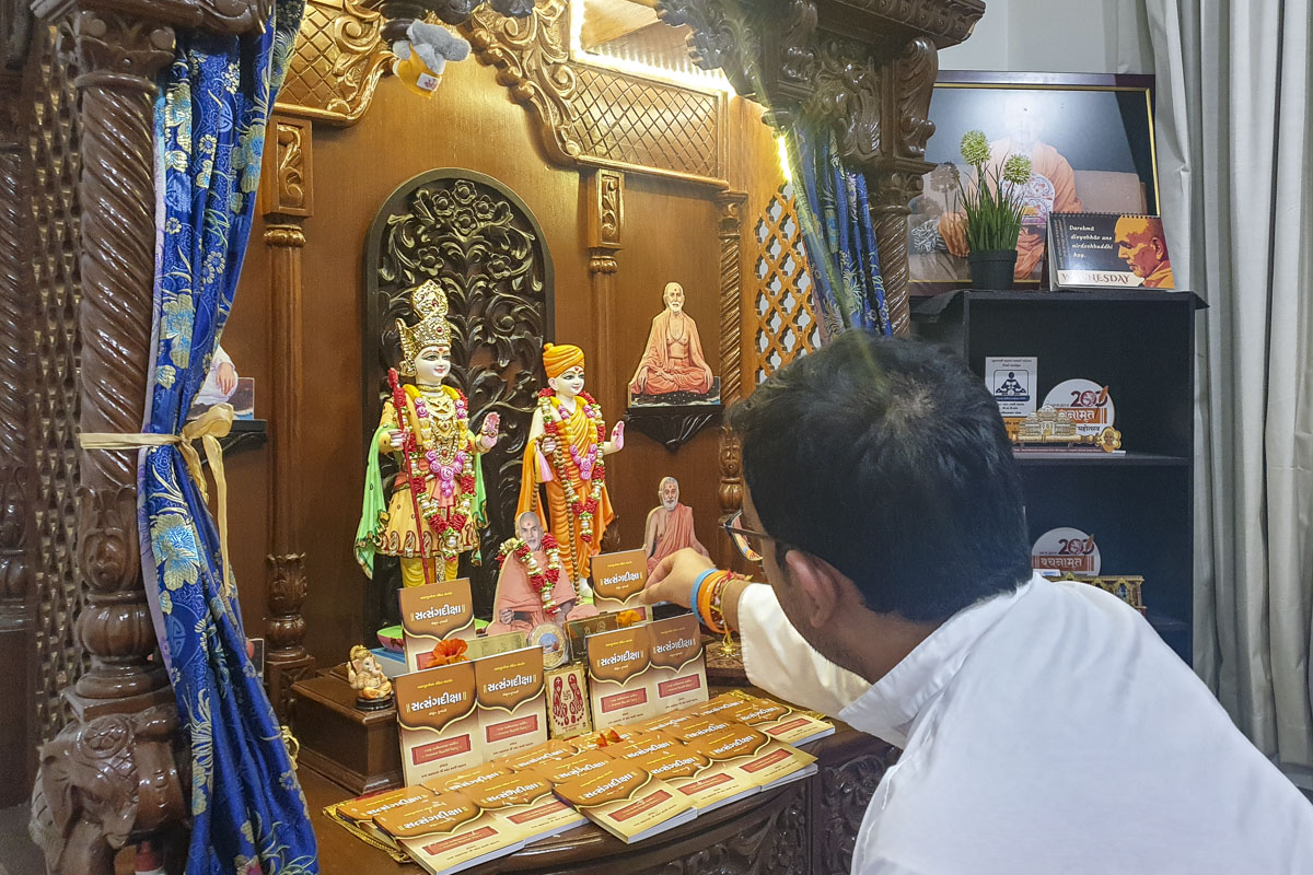 A devotee performs pujan of 'Satsang Diksha'