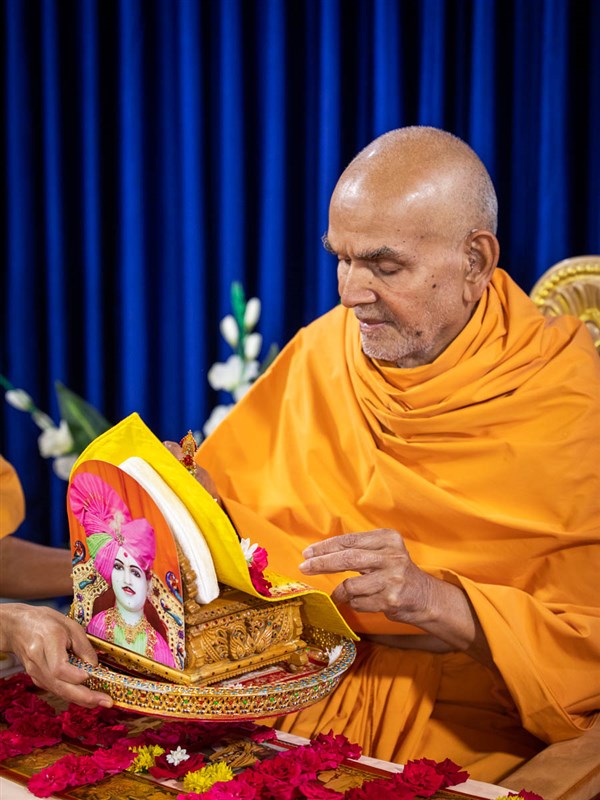 Swamishri honors Shri Harikrishna Maharaj with a garland