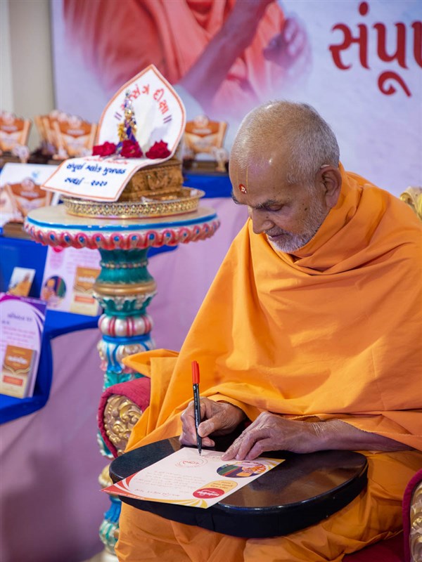 Swamishri signs a certificate