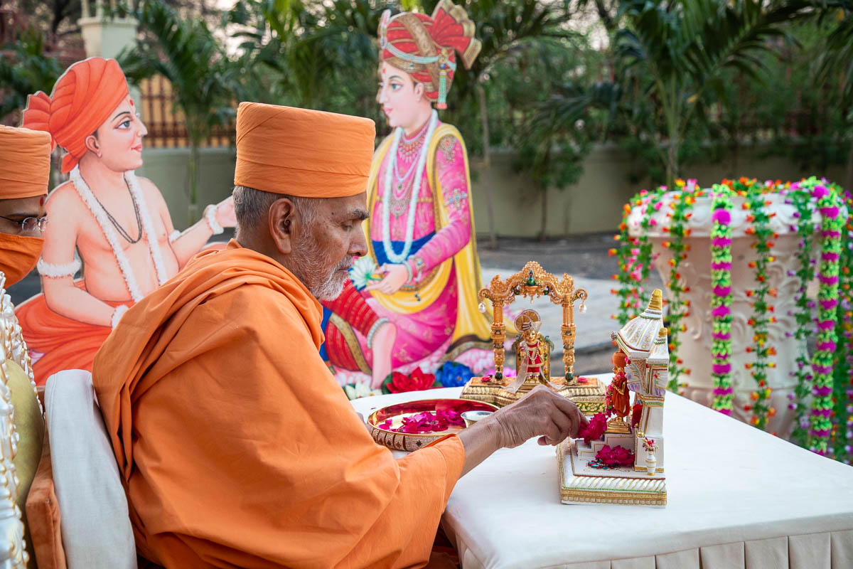 Swamishri offers flowers to Shri Gunatitanand Swami