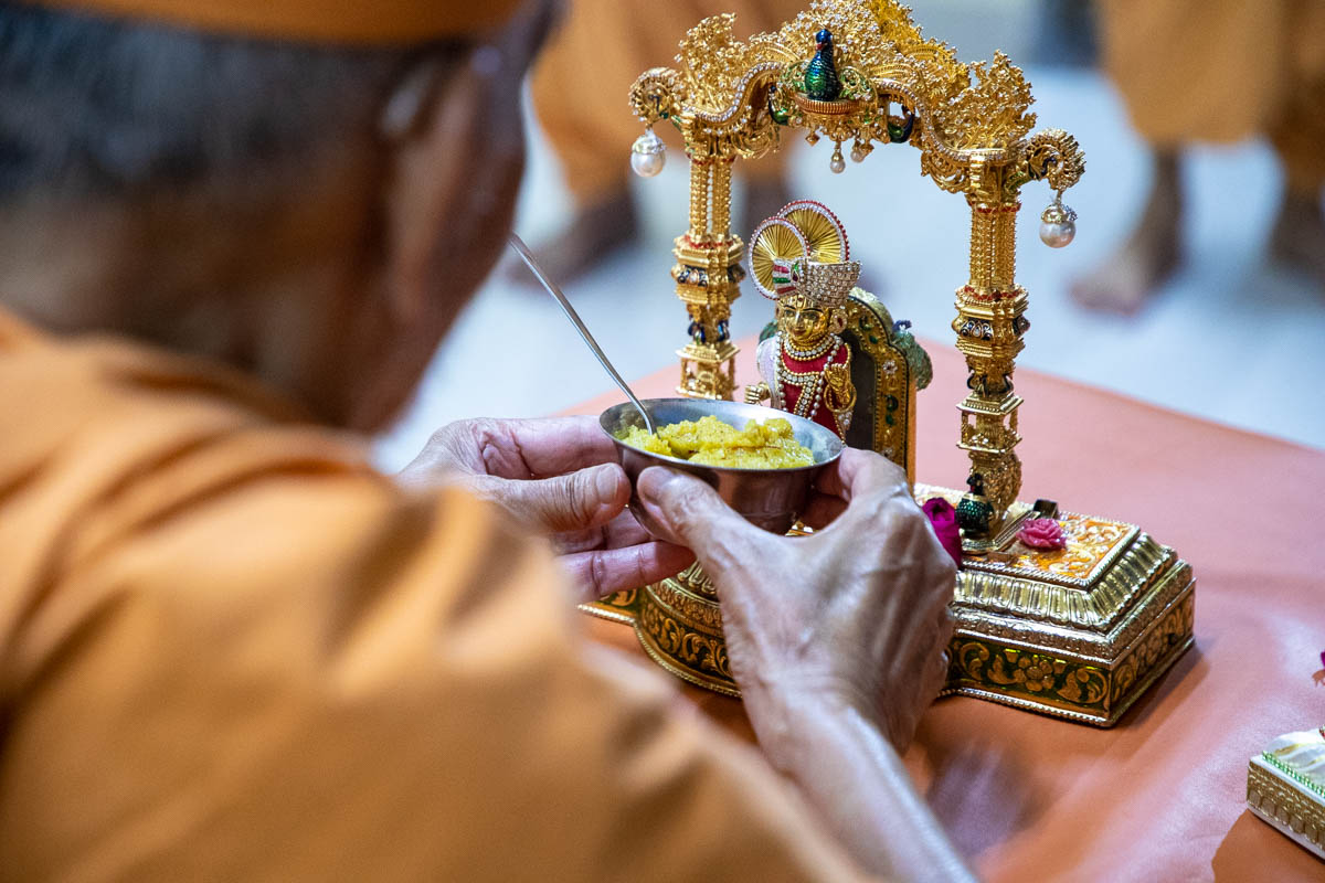 Swamishri offers shiro to Shri Harikrishna Maharaj