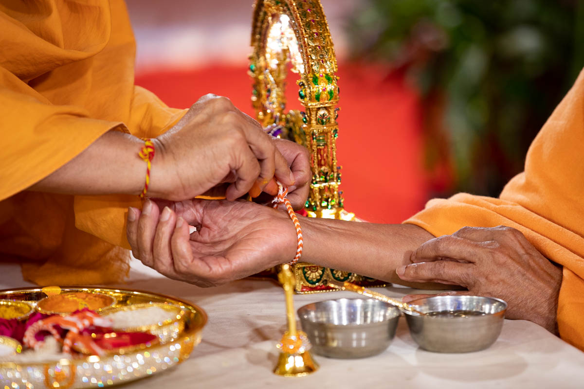 Atmaswarup Swami ties a nadachhadi to Swamishri