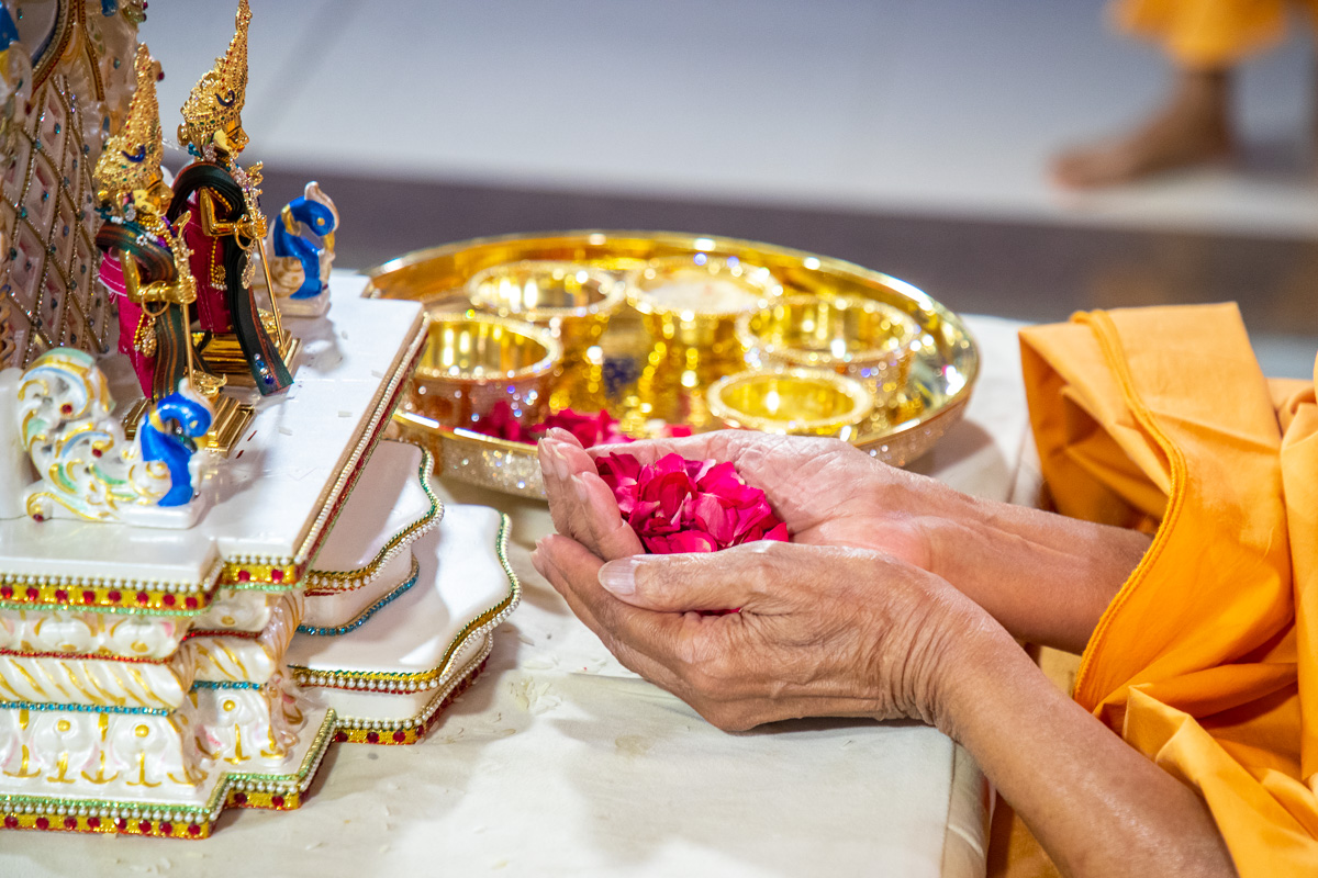 Swamishri offers flower petals to Shri Akshar-Purushottam Maharaj