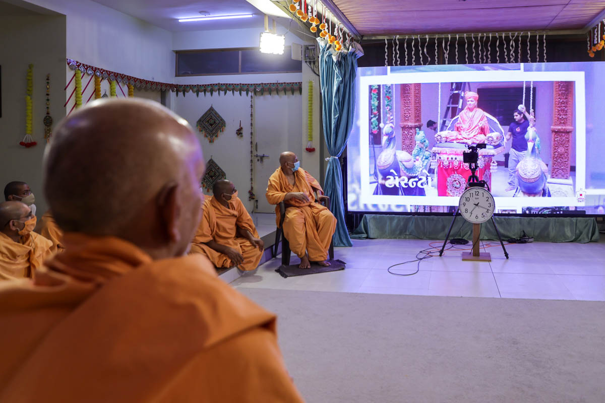 Swamishri watches a video of the Aksharbrahma Gunatitanand Swami Murti-Pratishtha Mahotsav celebrations held worldwide