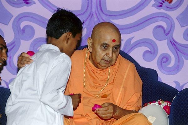  Swamishri blesses a child for getting an award in Satsang