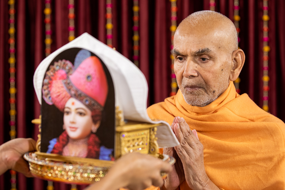 Param Pujya Mahant Swami Maharaj engrossed in darshan  of Shri Harikrishna Maharaj and Shri Gunatitanand Swami