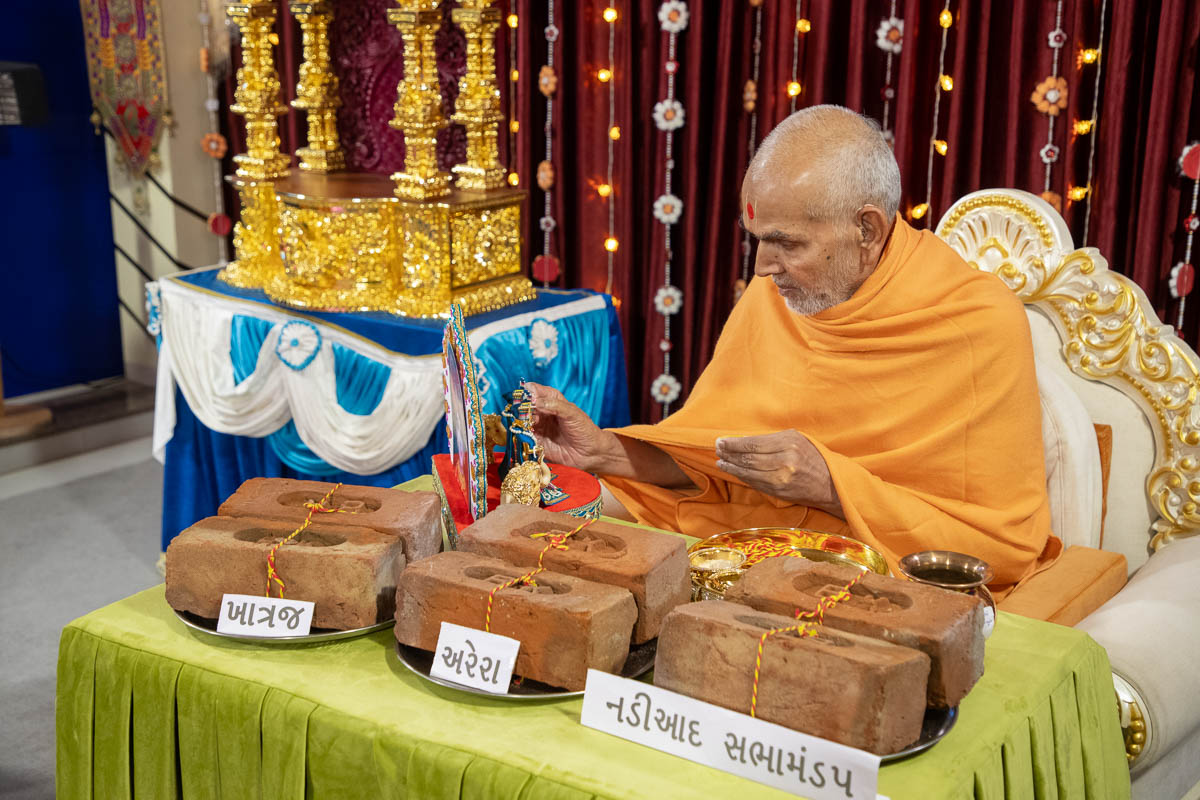 Swamishri sanctifies bricks for the new BAPS Shri Swaminarayan Mandirs at Khatraj and Arera, and the new assembly hall in Nadiad, India