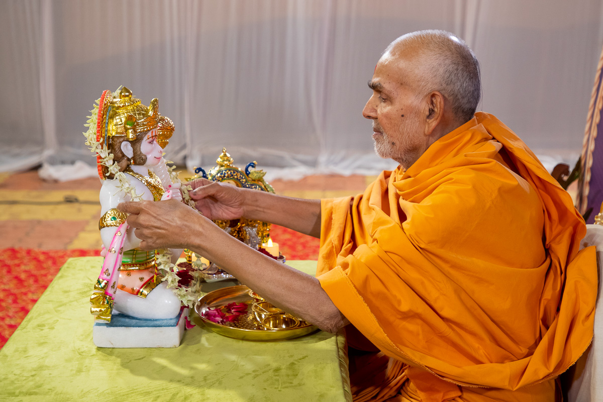Swamishri offers a garland to Shri Hanumanji