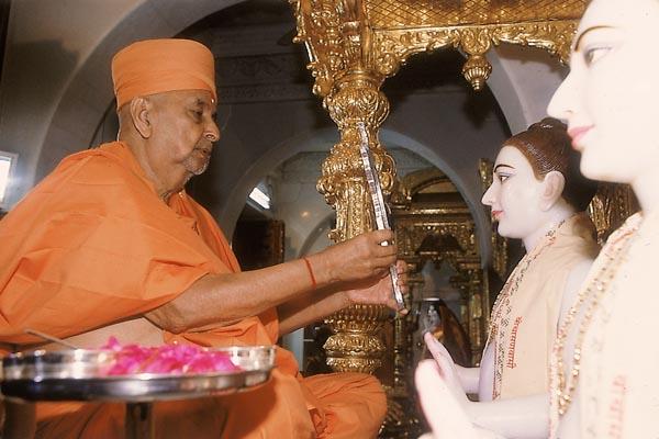  Swamishri holds a mirror for 'mukh darshan' ritual