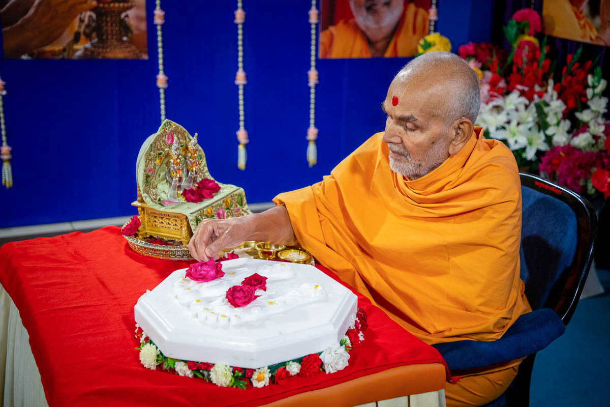 Swamishri offers flowers on the charanarvind