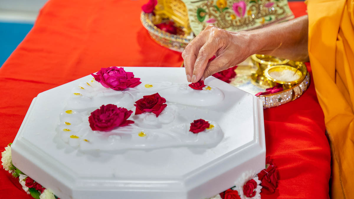 Swamishri offers flowers on the charanarvind