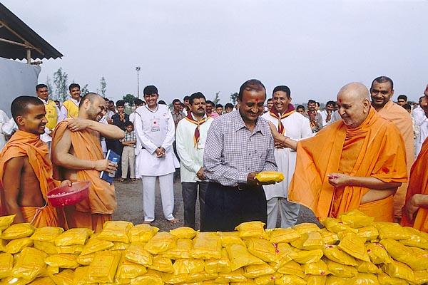 During the flood-relief program Swamishri on behalf of BAPS chapter of Jamnagar offers 10,000 food packets to the Collector 