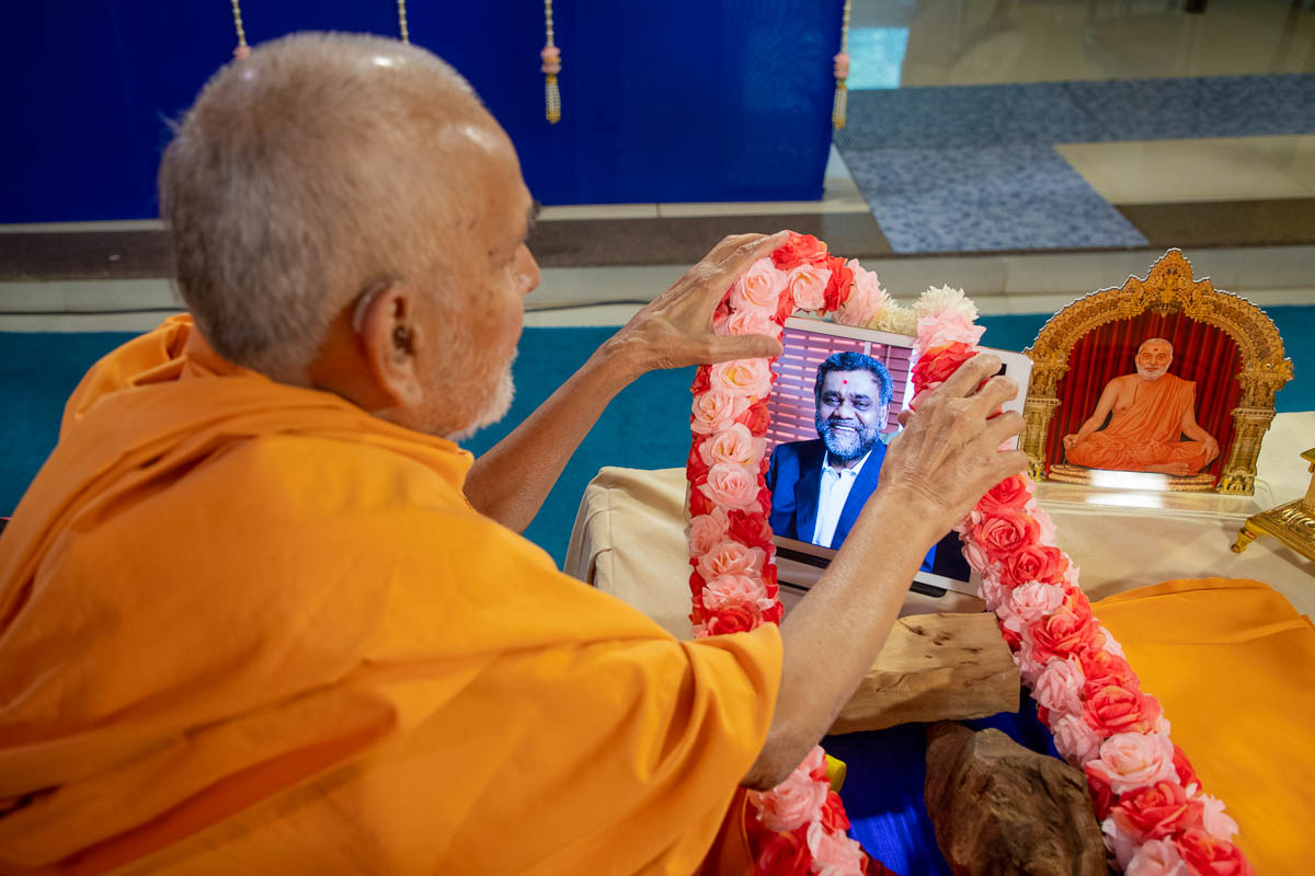 Swamishri honors Late Shri Subhashbhai with a garland