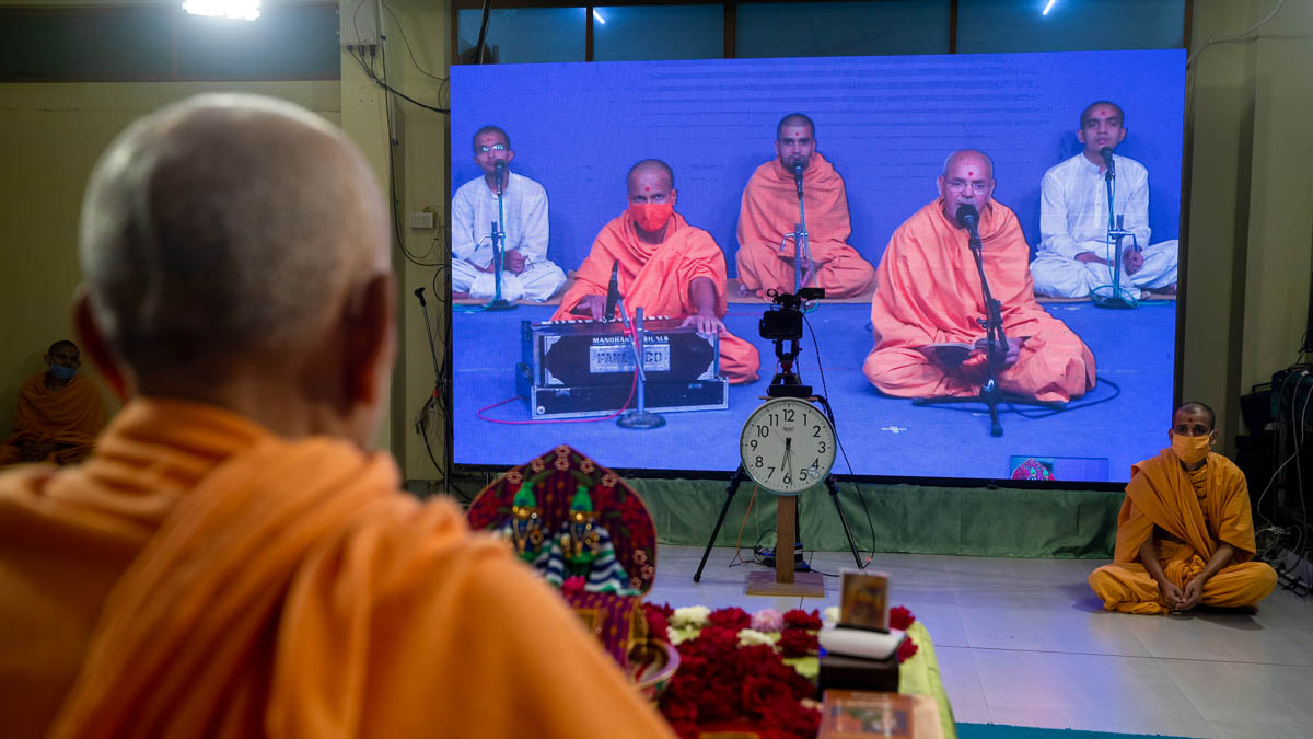 Aksharcharan Swami sings a kirtan via video conference from Sarangpur Mandir