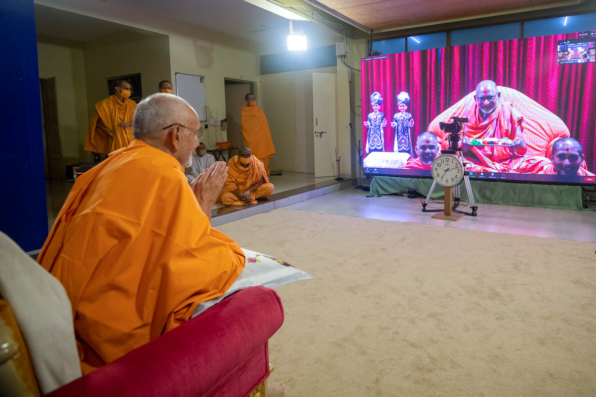 Pujya Bhaktipriya Swami (Kothari Swami) offers thal to Swamishri via video conference