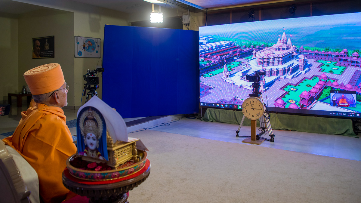 Swamishri watches a video presentation of the BAPS Shri Swaminarayan Mandir, Kanad, Surat
