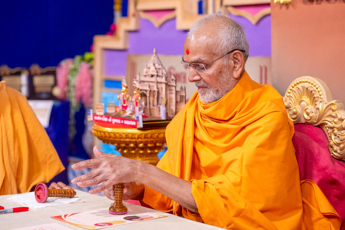 Swamishri applies a 'Rajipo' stamp of approval on a congratulations letter