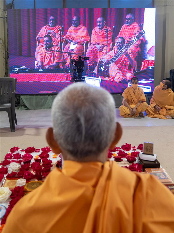 Mahant Swami Maharaj listened attentively to the kirtans from London while engaged in his puja in Nenpur, India
