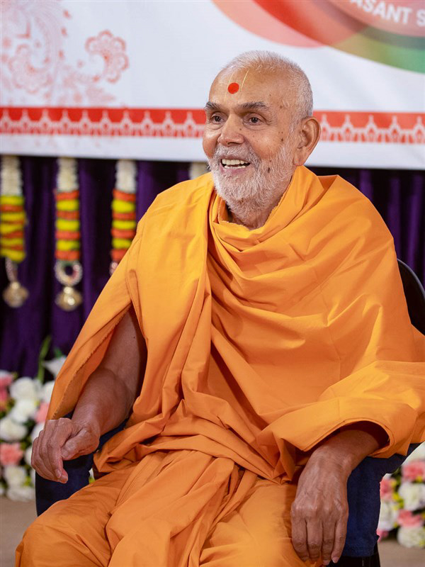 Mahant Swami Maharaj joyfully engaged with the swamis in London
