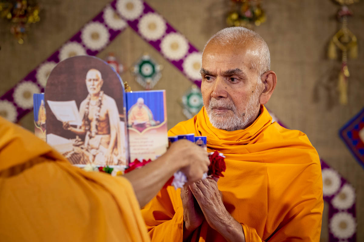 Param Pujya Mahant Swami Maharaj engrossed on darshan of Shri Harikrishna Maharaj and Shri Gunatitanand Swami