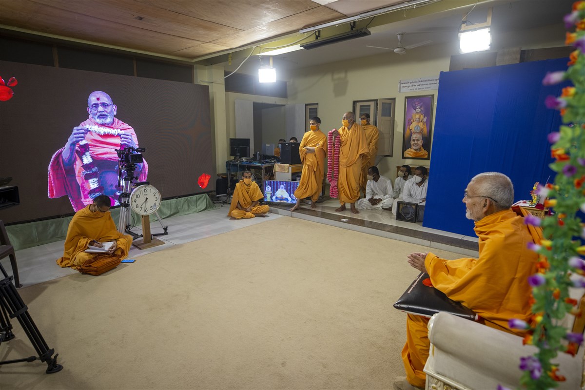 Yagnavallabh Swami honors Swamishri with a garland via video conference