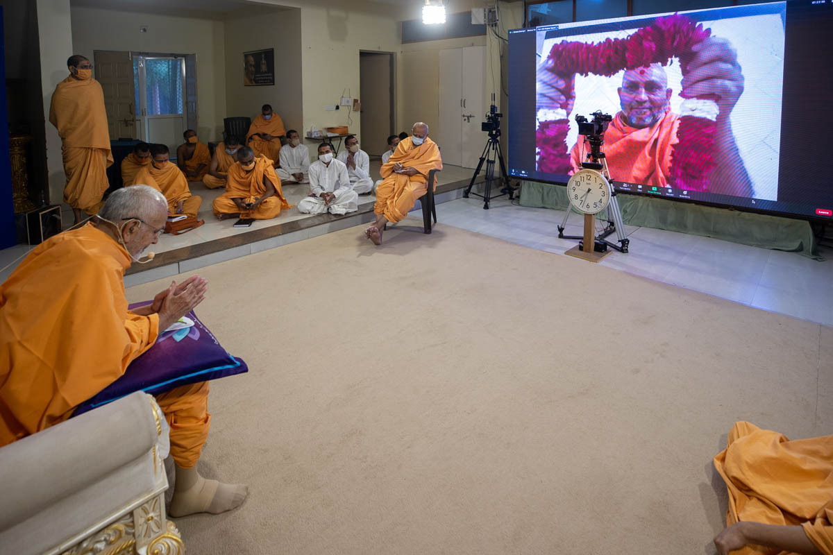 Amrutvatsal Swami honors Swamishri with a garland