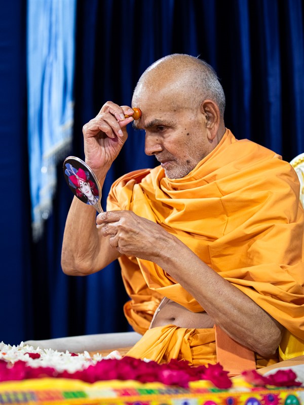 Swamishri applies a chandlo 